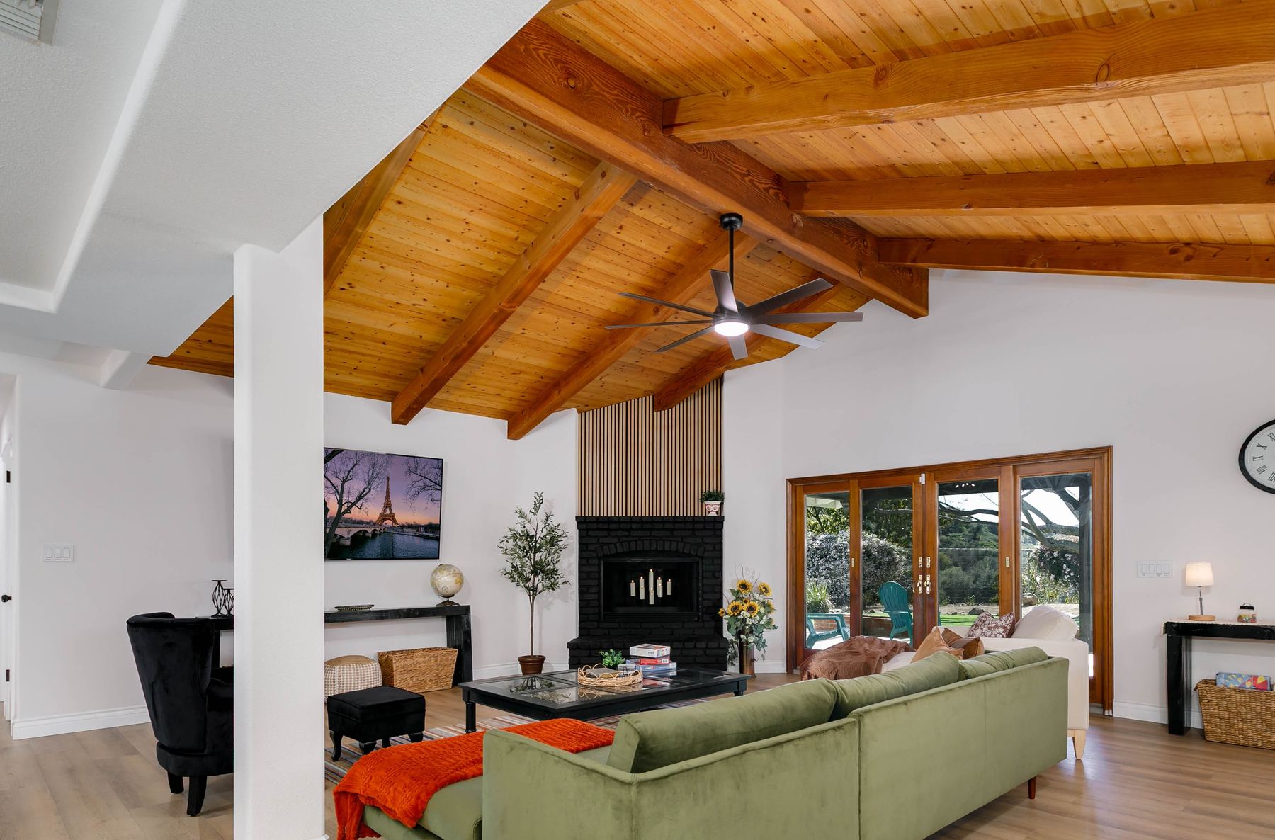 Living room with fireplace lit and wood beam ceiling