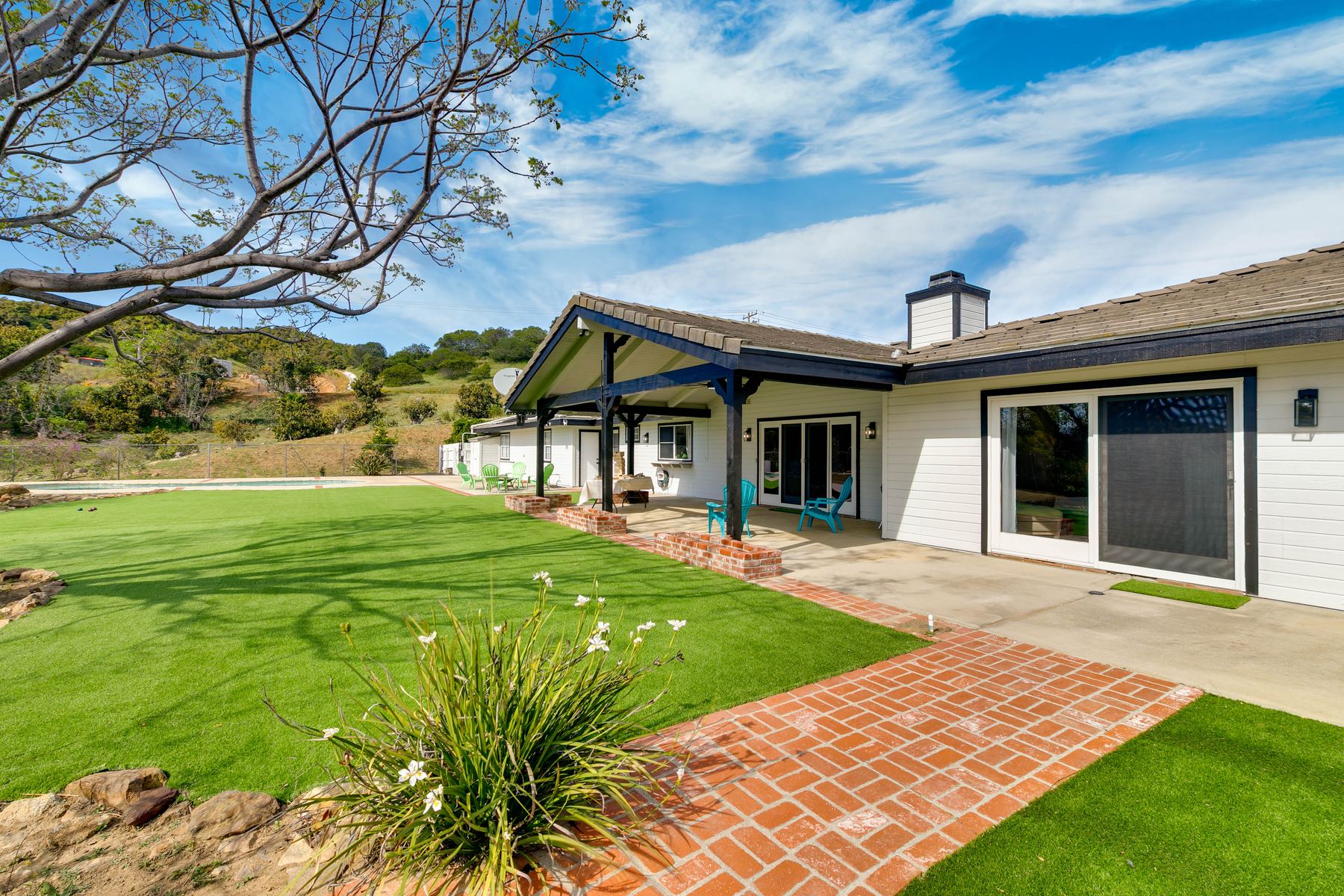 Covered patio with artificial turf lawn and outdoor seating